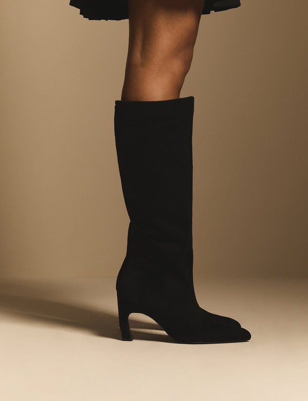 Side view of black suede pointed knee-high boots