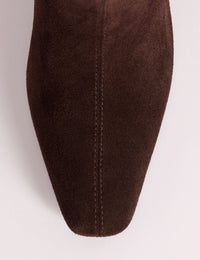 Pointed toe detail on brown suede boots