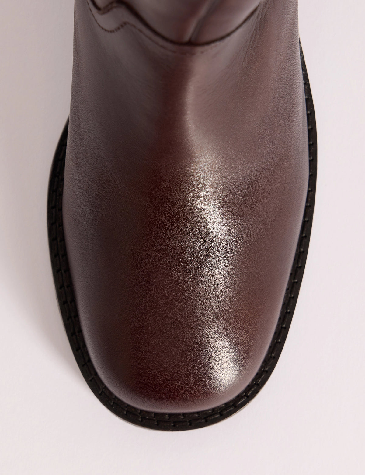 Round toe detail on brown leather knee-high boots