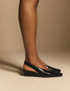 Side view of black leather wedge slingback heels