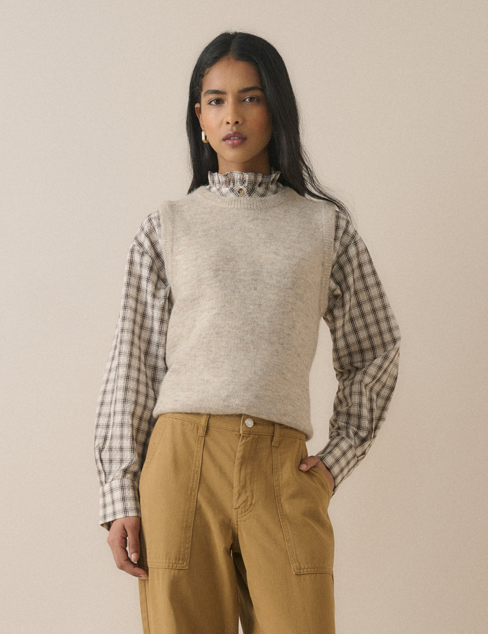 Grey check frill neck blouse layered under a knitted vest