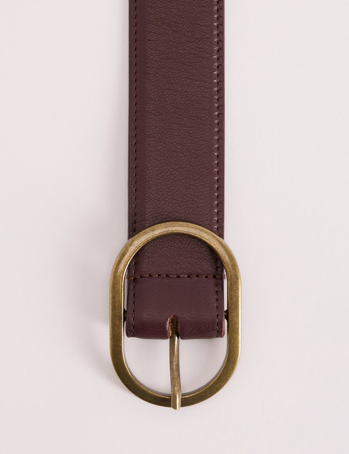 Gold-toned oval buckle on brown leather belt