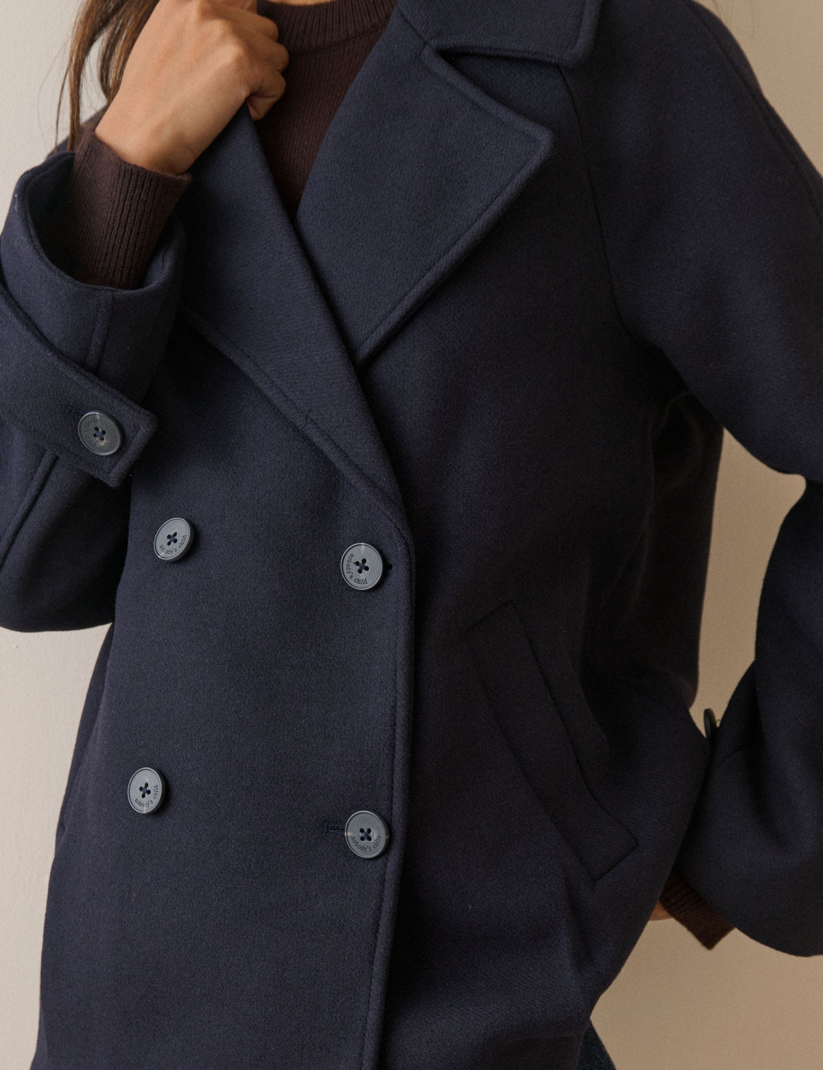 Collar and button detail on navy wool-blend pea coat