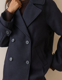 Collar and button detail on navy wool-blend pea coat