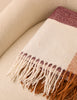 Fringed hem detail on burgundy and tan check throw