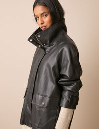 Side view of black leather funnel neck jacket