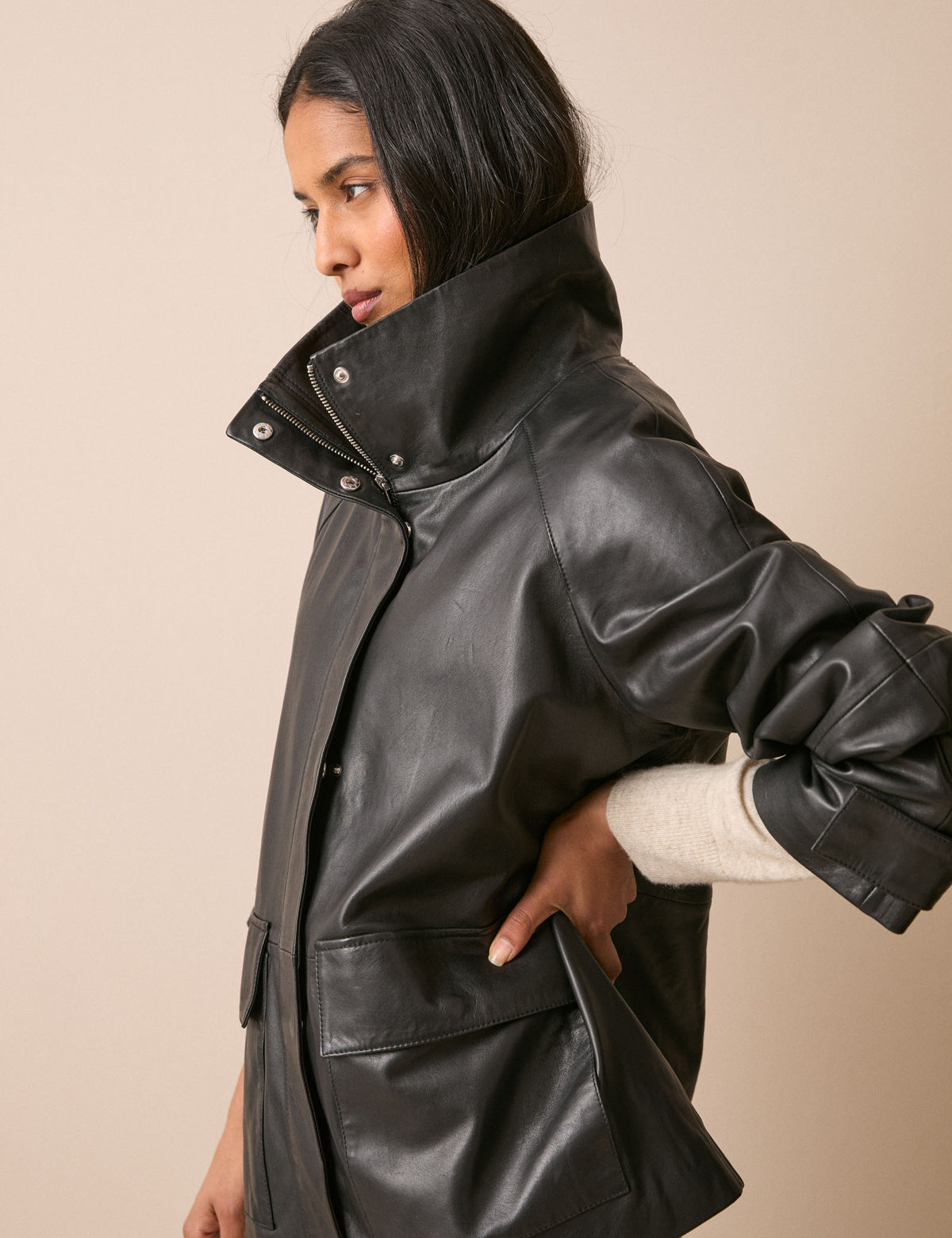 Side view of black leather funnel neck jacket