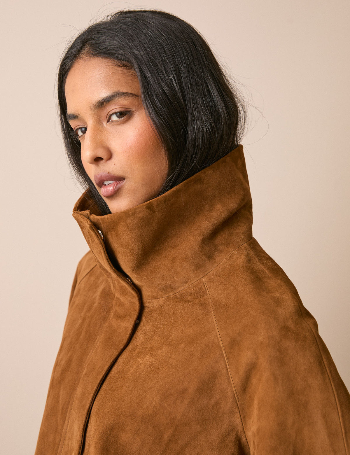 Funnel neck detail on tan suede jacket