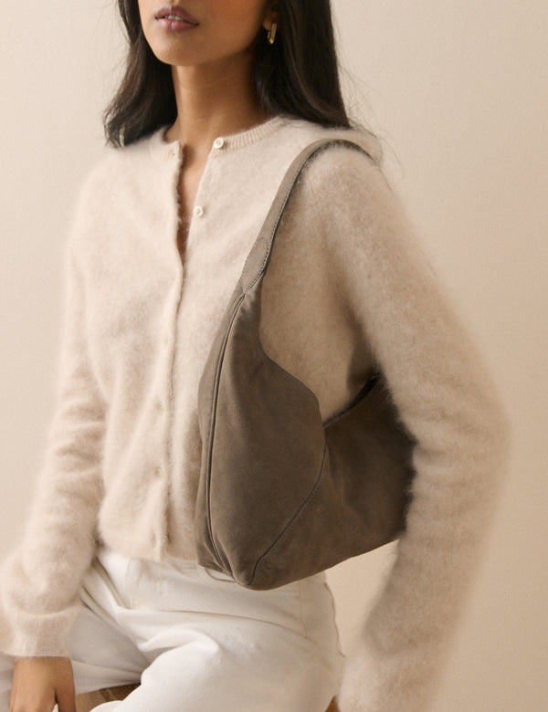 Grey suede shoulder bag worn over the shoulder