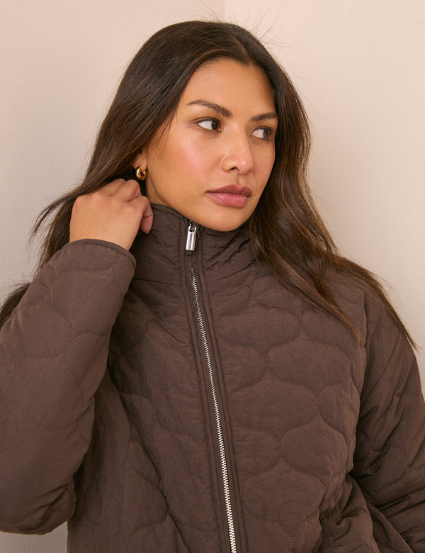 Funnel neck detail on brown quilted jacket